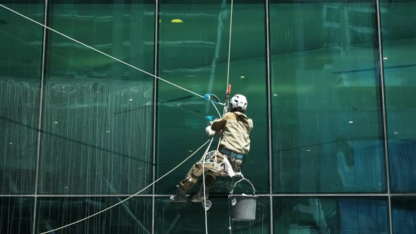 Window Cleaner at Work Washing Office Building Glass Facade alt