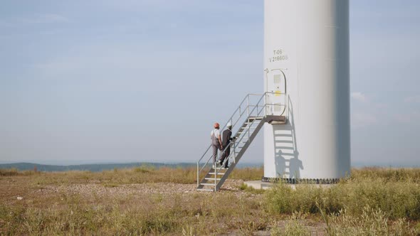 African American Inspector in Black Suit and White Helmet Talking with Indian alt