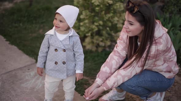 Cute Little Girl with Her Mom Play with Little Dog Outside. Yorkshire Terrer Play and Jump. Adorable alt