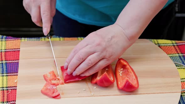 Senior Caucasian Woman Cut Sweet Red Bell Pepper on Wooden Cutting Board