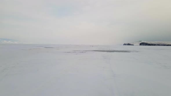 Baikal Lake Landscape with Cracked Frozen Ice Surface Covered with Snow in Winter alt