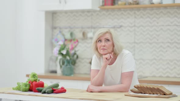 Worried Senior Old Woman Thinking While Standing in Kitchen alt