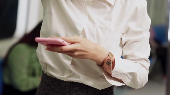 Young Woman Using Mobile Phone on Public Train alt