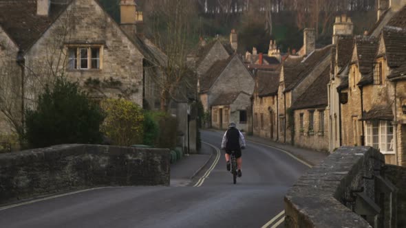 Biker passing through an old stone village in England. alt