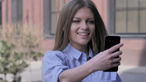 Woman Outside Office Taking Selfie on Smartphone alt