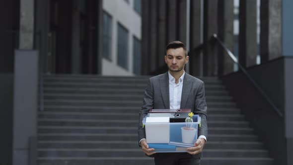 Businessman Gets Fired and Walking Near Office Center With Box Documents