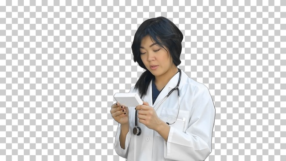 Doctor woman looking at box of pills, Alpha Channel