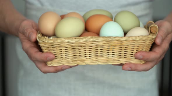 Farmer Male Hands Hold Wicker Basket with Rustic Fresh Chicken Eggs