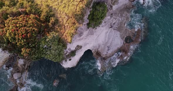 Aerial - Wide angle of Cathedral Cove New Zealand. Looking down on crashing waves alt