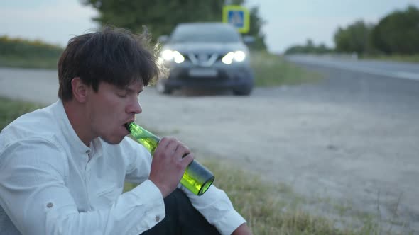 Nersous Man Sits on the Grass and Waits for the Help alt