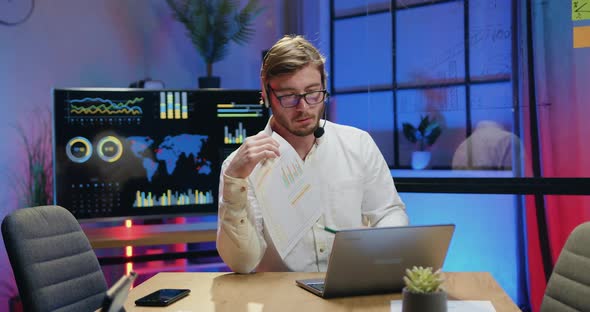 Office Manager in Headset Explaining Report with Charts During Video chat alt