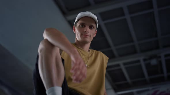 Attractive Man Resting at Urban Skate Park alt
