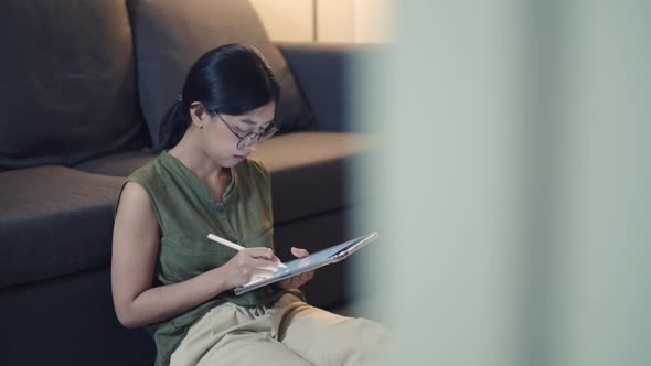 Asian female reading news on her digital tablet.