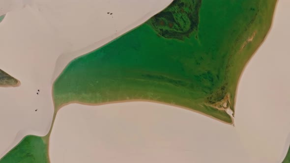 Drone Flying High, Pointing Down, Shows Clear Water Of A Lagoon Around A Dune, Brazilian Paradise