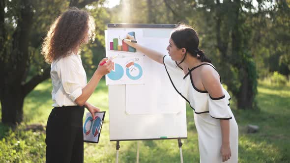 Side View Two Young Women Discussing Business Idea Outdoors Arguing in Slow Motion alt