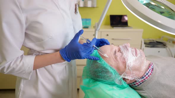 Middle Aged Man Getting Biorevitalization Procedure in Beauty Clinic alt