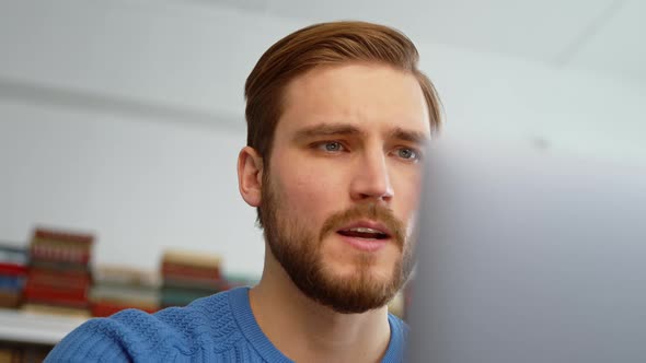 Upset male receiving bad news using computer at home alt