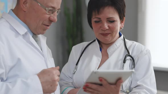 Closeup view of man and woman doctors using tablet during working day at clinic.