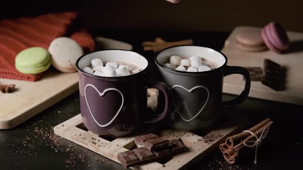 Man Putting Marshmallows Into a Cup of Cocoa alt