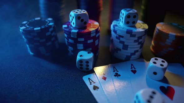 Casino Chips with Dice and Playing Cards on a Dark Table alt