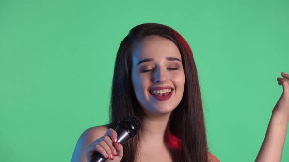 Portrait of Beautiful Young Woman Illuminated By Blue Red Neon Light Sings Song Into Microphone alt
