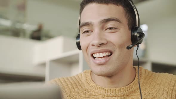 Smiling Handsome Latinos Man Communicates Via Video Link with a Headset on His Head Consulting alt