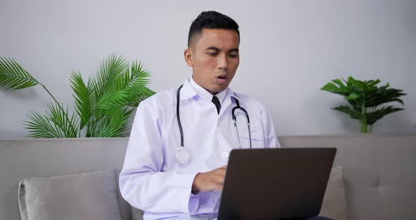 Doctor talking to patient making video call on laptop alt