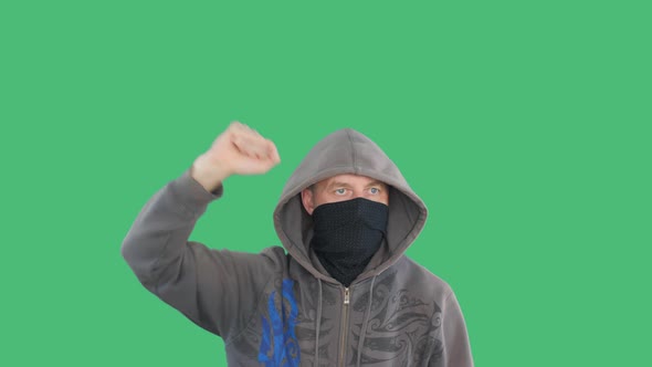 Protestant Gesticulating Fists Social Rally on Green Background. Furious Man in Bandana and Hood alt