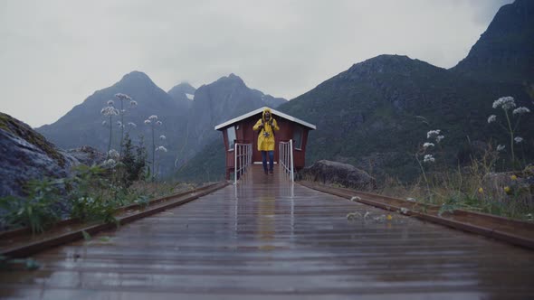 Traveler walking on wet pier in mountains alt