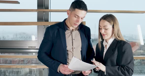 Man and a Woman Discussing Work in the Brightly Lit Modern Office. Concerned Male and Female Working alt