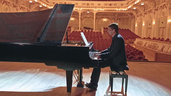 Pianist Playing on a Grand Piano on Big Stage in Concert Hall