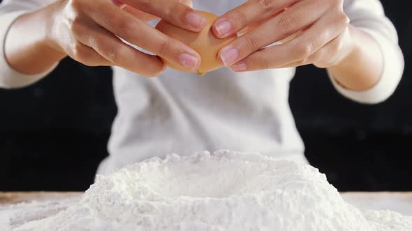 Woman adding egg white into flour alt