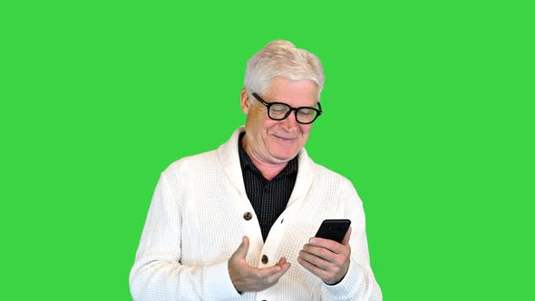 Satisfied Old Man Using His Smartphone on a Green Screen Chroma Key alt