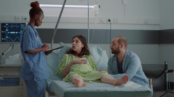 Nurse of African American Ethnicity Using Tablet for Pregnant Woman alt