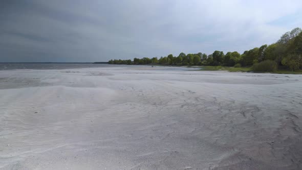 The wind drives sand along the Baltic beach