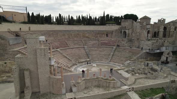 Aerial Orbiting view of tourists in Roman Theatre in Cartagena. Spain