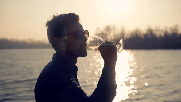 Man Drinking White Wine On Holidays Vacation. Romantic Evening Enjoying Wineglass. alt