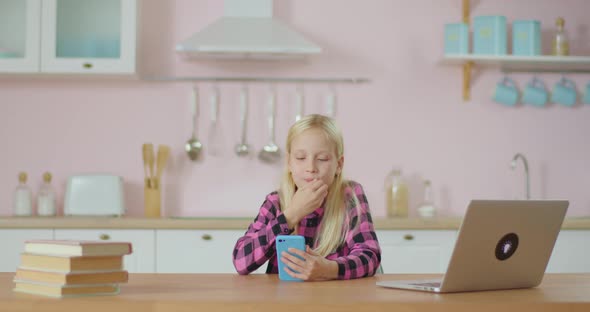 School Preteen Girl Using Mobile Phone Application for Watching Popular Video Online. Kid Stays at