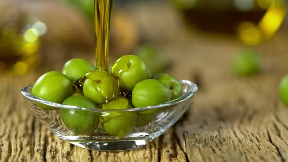 Super Slow Motion Shot of Pouring Fresh Olive Oil on Olives at 1000 Fps. alt