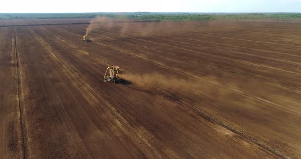 Peat Harvester Machines Collecting Peat Dust on Field Aerial View alt