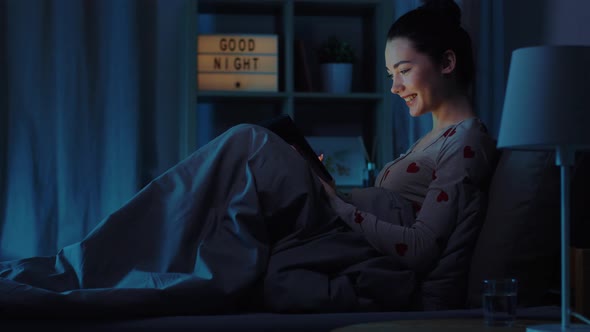 Teenage Girl with Tablet Pc in Bed at Night