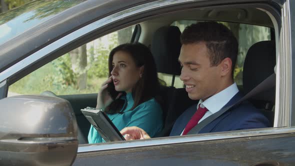 Multiethnic Business Couple Works Together in Car alt