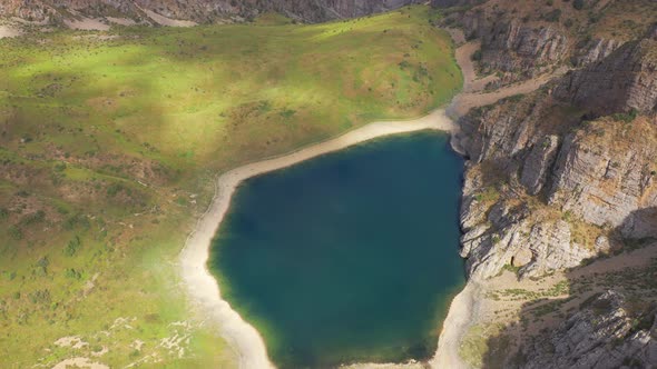 Panorama a Mountain Lake with Turquoise Water and Green Grass. Reflection Sky and Clouds in the alt
