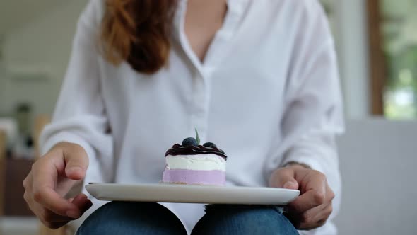 Woman Eat Cake 2Closeup of a woman eating a piece of blueberry cheesecake