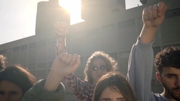 Group of Activist People Standing Looking at Camera with Fist in the Air During a Protest March alt