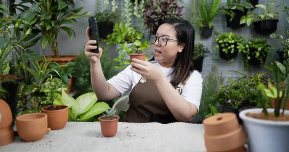 woman sell plant online with smartphone alt