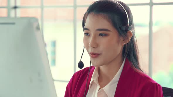 Businesswoman Wearing Headset Working Actively in Office alt
