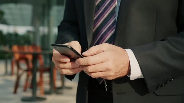 Male Reading Phone Message or Downloading an App for His Mobile Phone alt