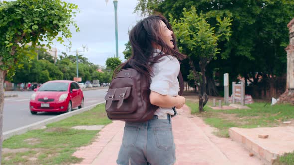 Asian backpacker blogger woman tourist hold camera walk and run lead with happy smile excited trave alt