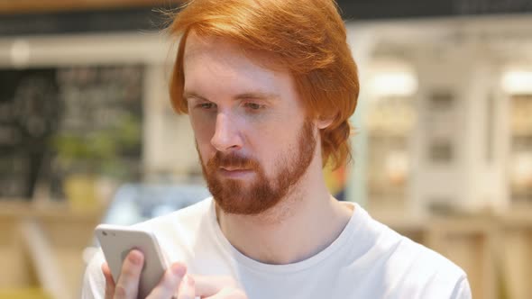 Redhead Beard Man Using Smartphone for Online Browsing alt